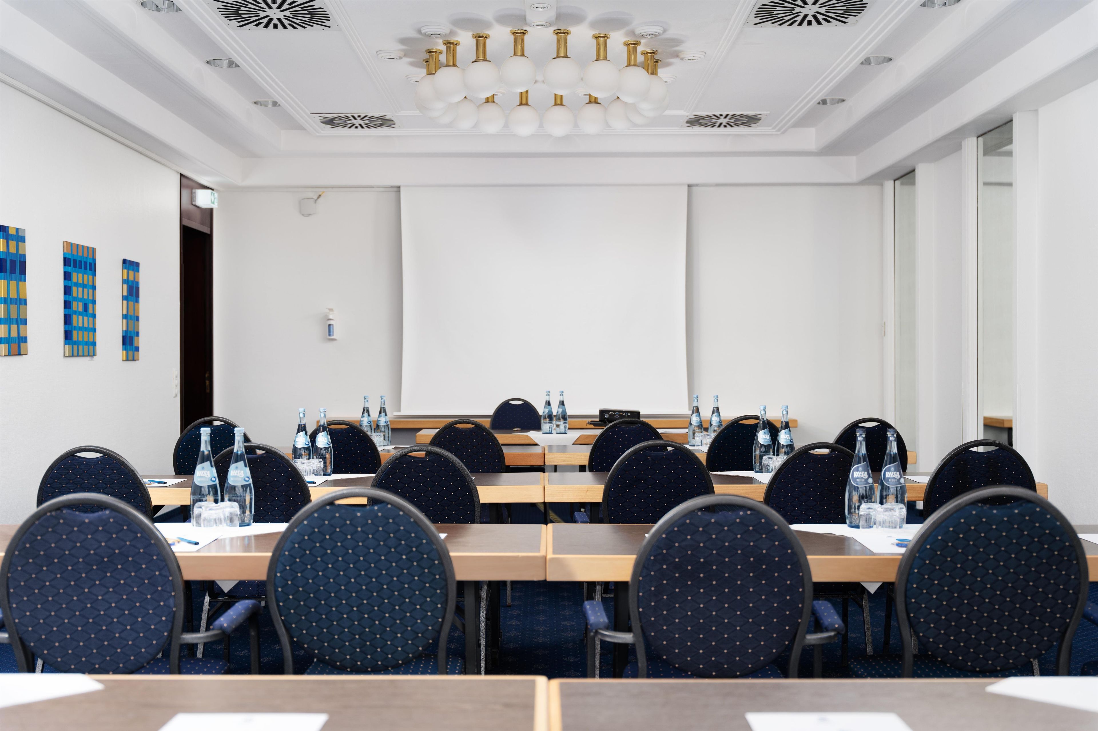 A conference room with a long table, chairs, and water bottles.