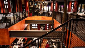 A multi-level restaurant with tables and chairs arranged on different floors, connected by a central walkway.