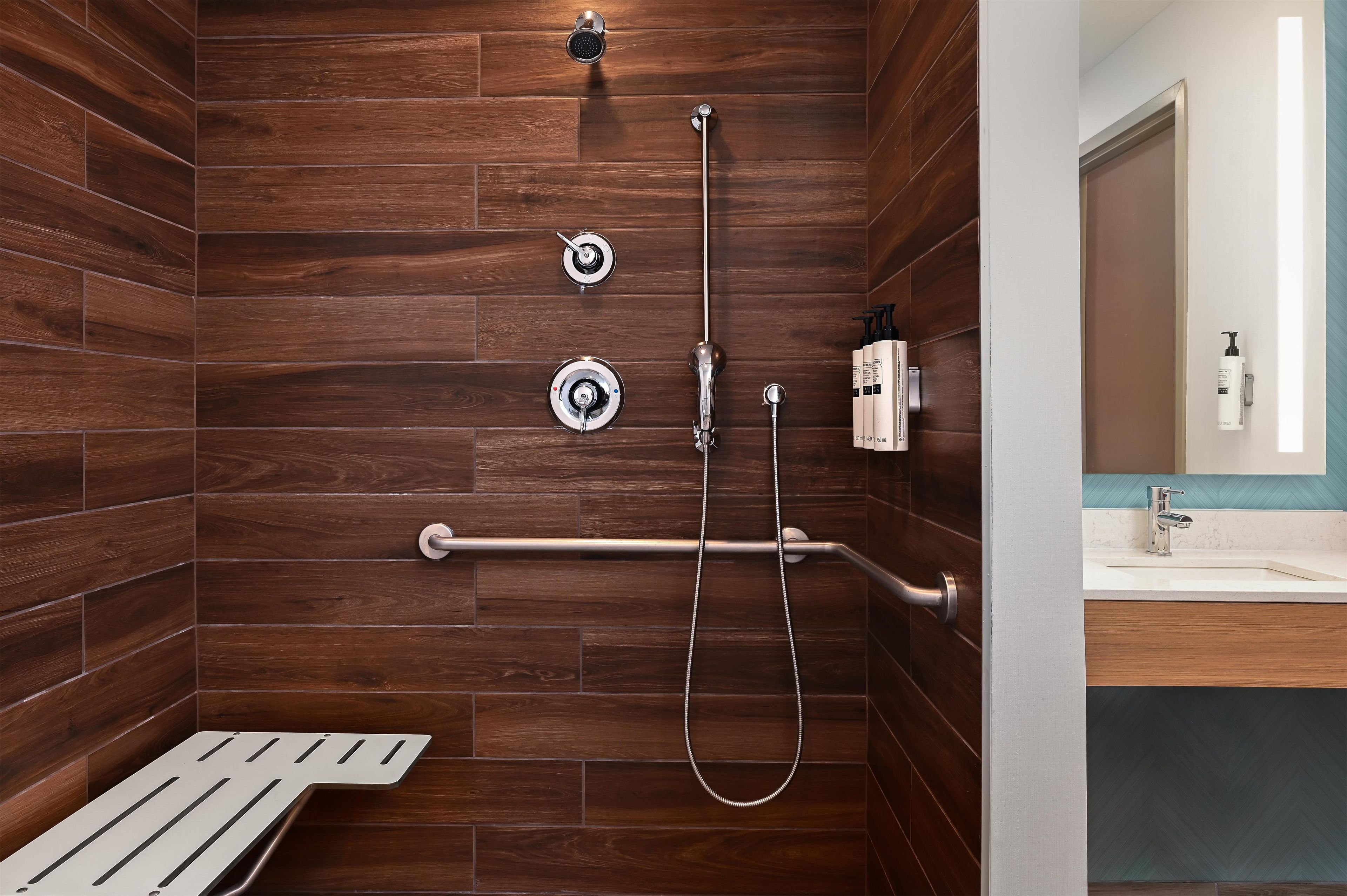 Un espace douche avec un mur en bois, une pomme de douche à main et un flexible de douche à main.