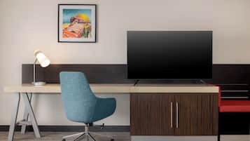 A modern office desk with a swivel chair, a flat-screen TV, and a framed picture on the wall.