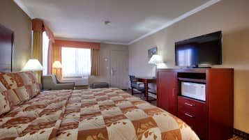 Une chambre d’hôtel avec un grand lit, une télévision, un bureau avec une chaise et un four à micro-ondes.