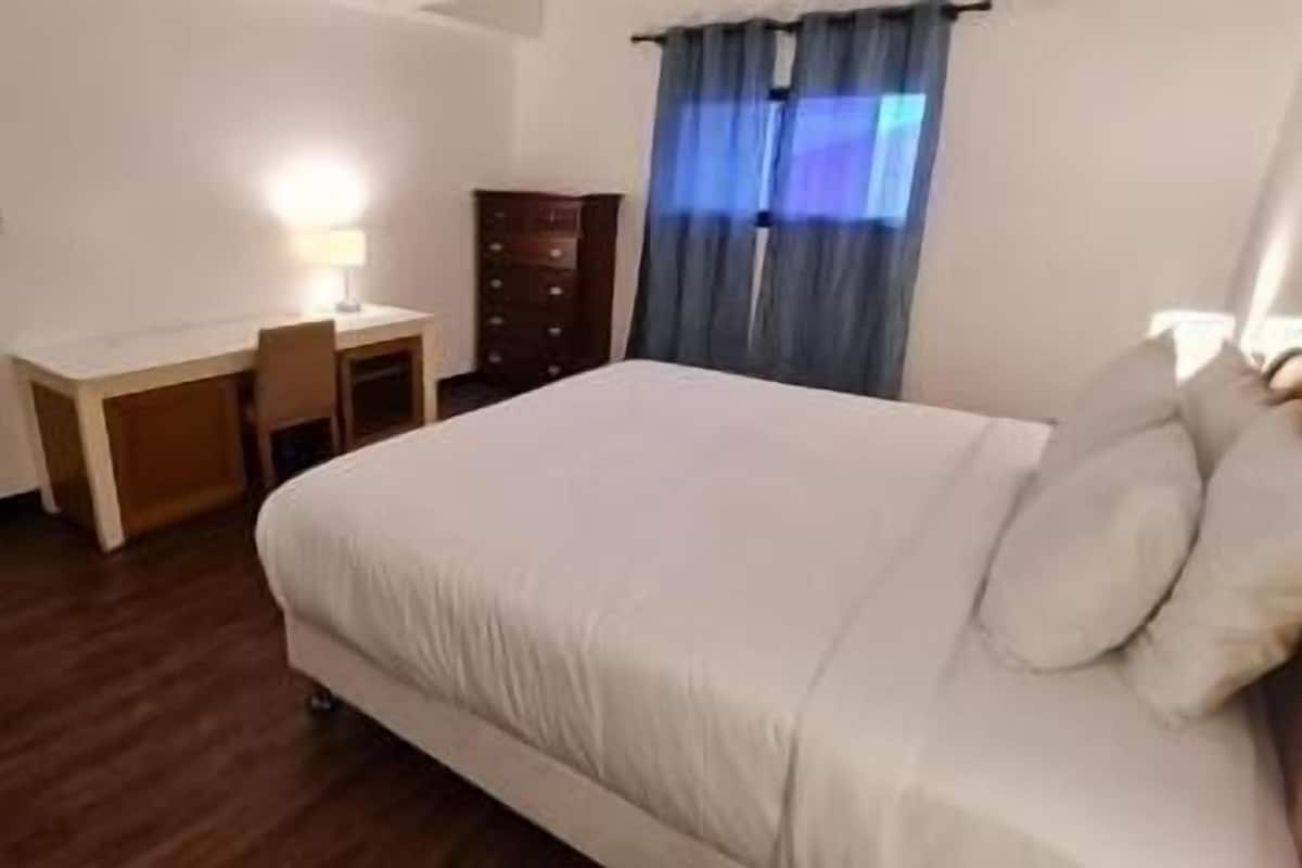 Ein Hotelzimmer mit einem Bett, einem Schreibtisch und einer Kommode.