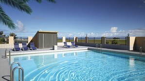 A swimming pool with lounge chairs and a view of the ocean. - SureStay Hotel by Best Western Guam Airport South (Barrigada)