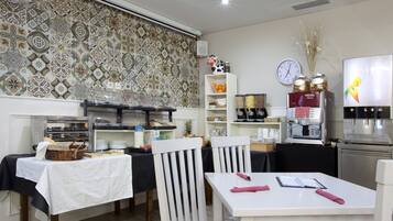 Un comedor con mesas de buffet, un reloj y una máquina de café.