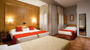 Habitación de hotel con dos camas, cabeceros de madera y un espejo grande.