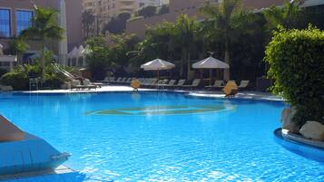 Una piscina cubierta, una piscina al aire libre, tumbonas