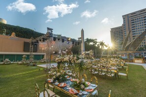 An outdoor wedding setup with tables arranged on grass, decorated with flowers and table settings. - InterContinental Cairo Citystars by IHG (Cairo)