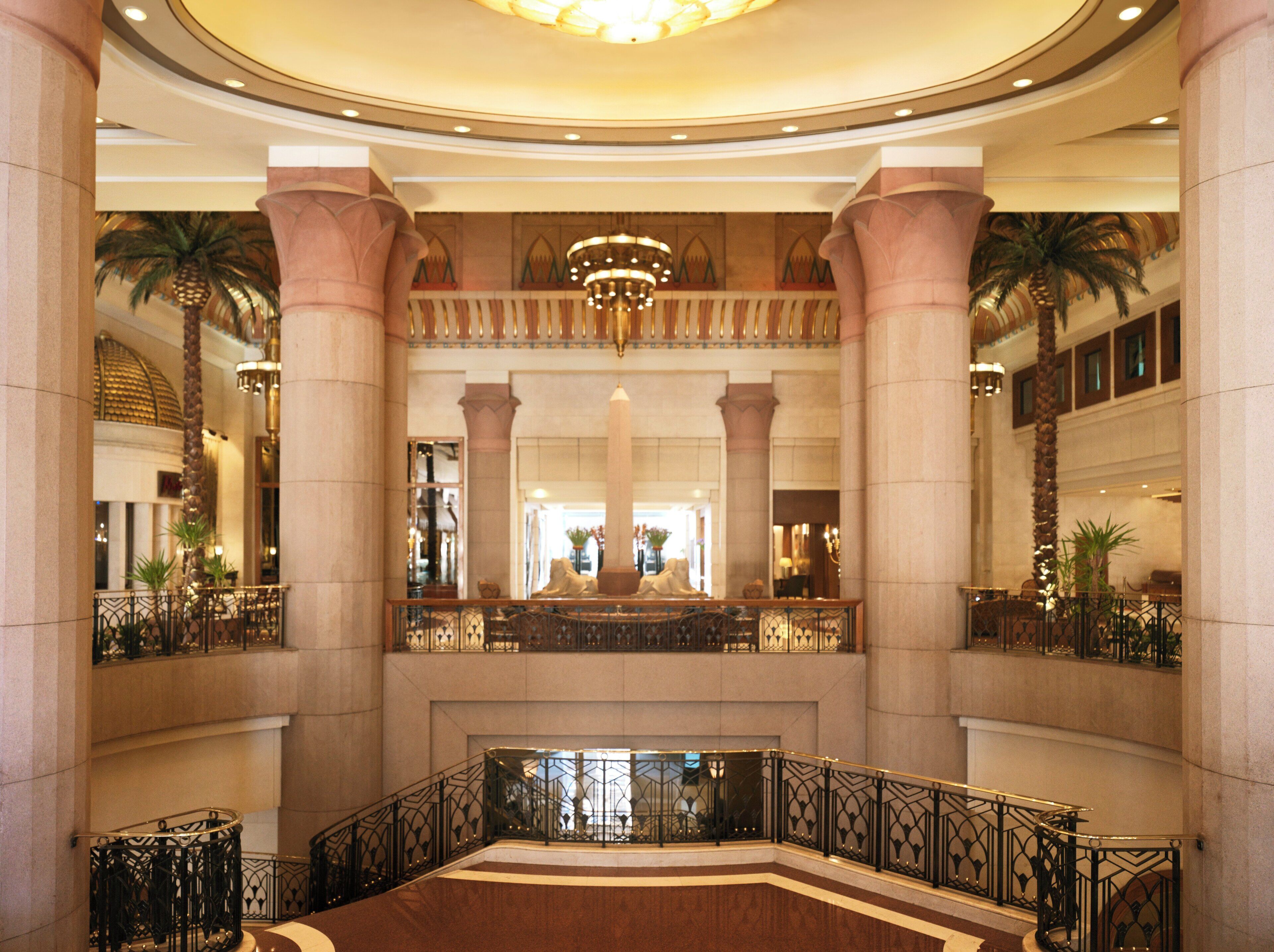 A grand lobby with a central fountain, high ceilings, and ornate columns.