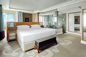 A spacious bedroom with a large bed, a bedside table, a mirror, and a view of the city. - InterContinental Cairo Citystars by IHG (Cairo)