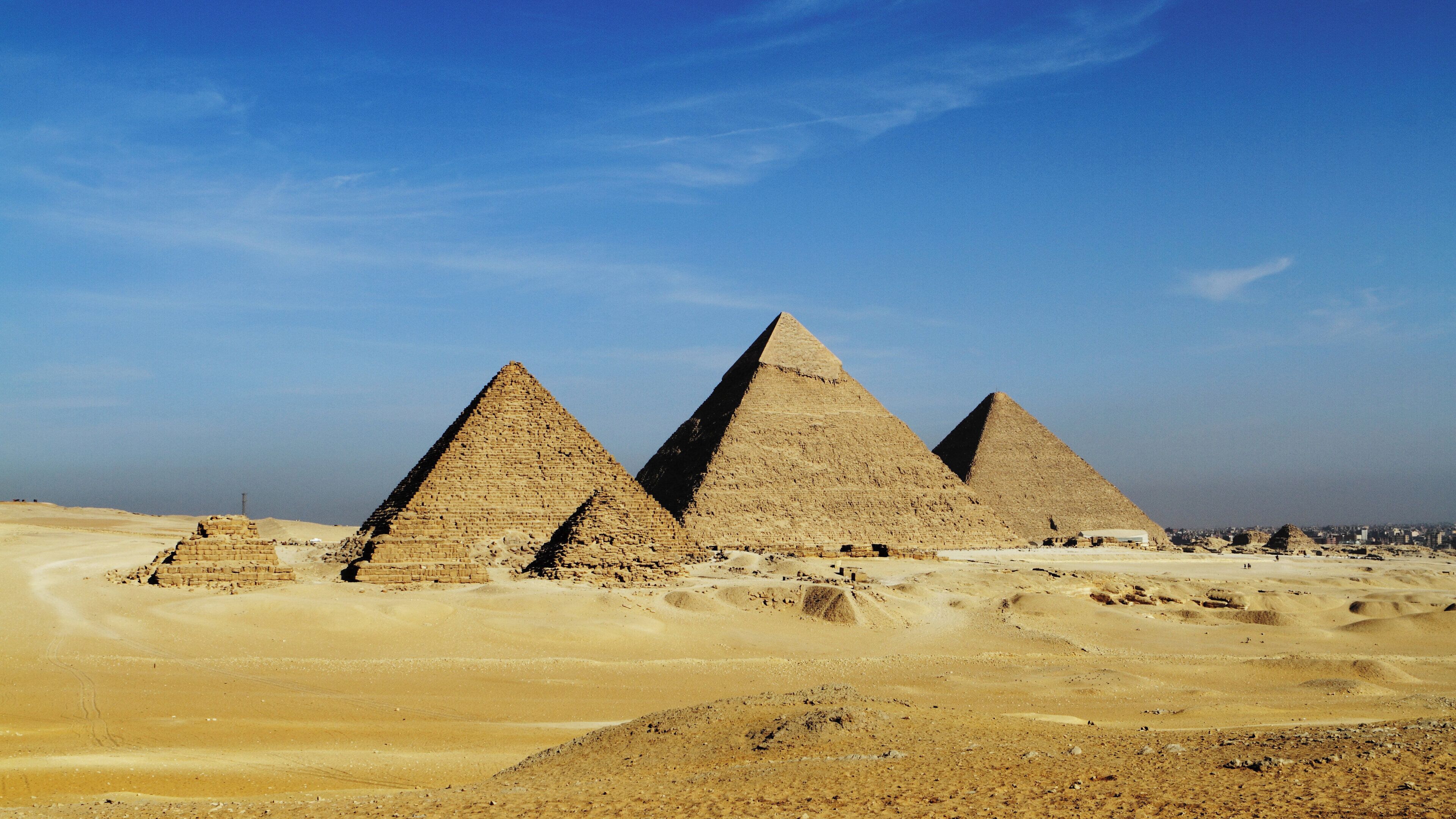 Three large pyramids in a desert landscape.