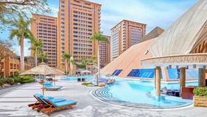 A resort pool area with sun loungers, a large pool, and high-rise buildings in the background. - InterContinental Cairo Citystars by IHG (Cairo)