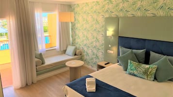 A hotel room with a bed, a sofa, a small table, and a window with curtains.