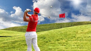 A golfer on a grassy hill with a red flag in the distance. - Adonis Le Chastellan (Guillaumes)