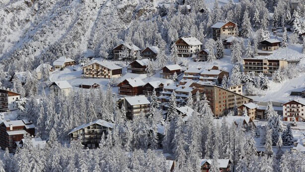 A snow-covered resort with multiple lodge buildings surrounded by dense trees. - Adonis Le Chastellan (Guillaumes)