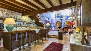 A rustic bar area with wooden beams, a stone wall, and a staircase leading to an upper level. - Hotel Rural S'Olivaret & Spa (Alaro)