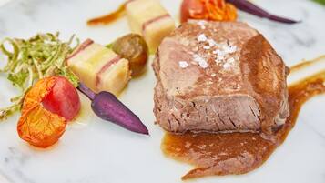 Un plato de comida con carne, verduras y salsa.