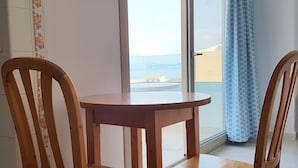 Een houten tafel en stoelen in een kamer met een groot raam.
