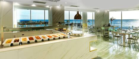 Cocina moderna con bufé, ventanas amplias y vista al océano.