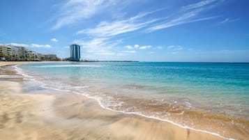 Di pantai, kursi berjemur, payung pantai, dan handuk pantai