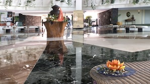 A spacious lobby with a high ceiling, multiple levels, and hanging plants. - Hotel Beatriz Costa & Spa (Teguise)