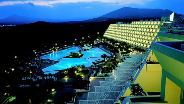 A resort with multiple swimming pools, a large hotel building, and a mountainous backdrop. - Hotel Beatriz Costa & Spa (Teguise)