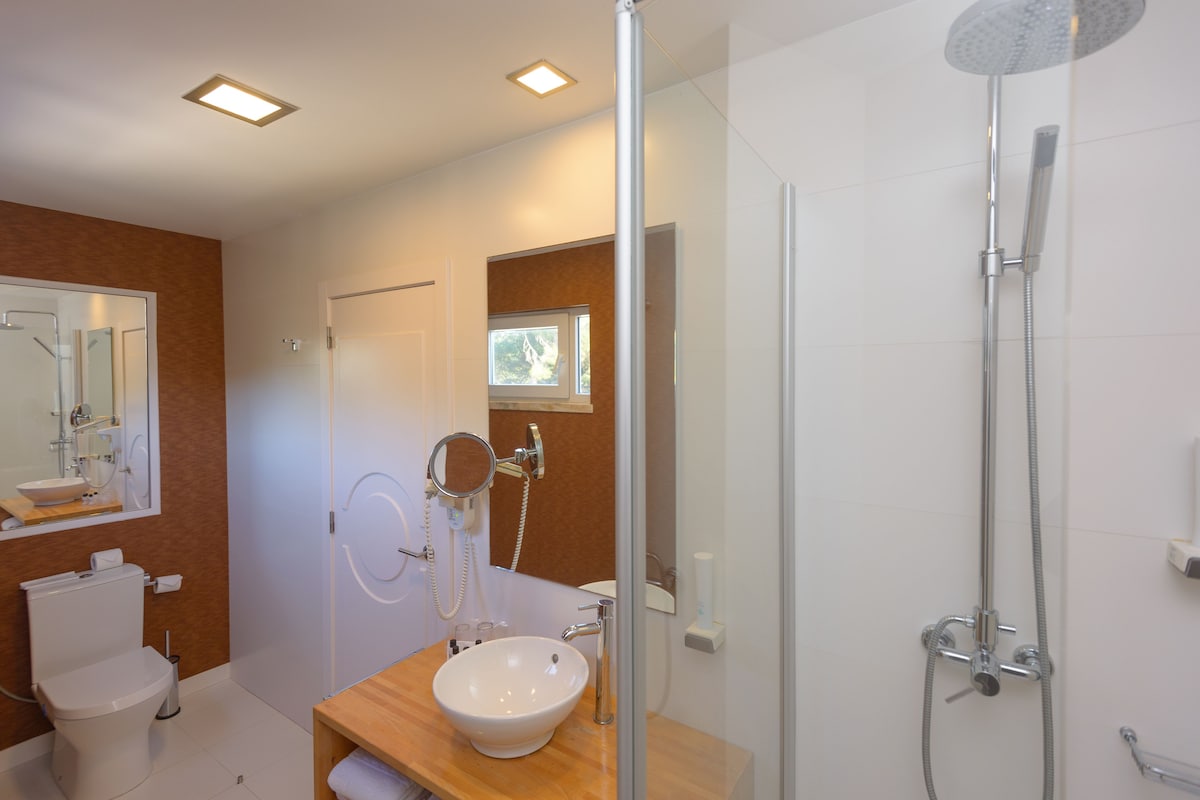 Ein modernes Badezimmer mit Toilette, Waschbecken und Dusche.