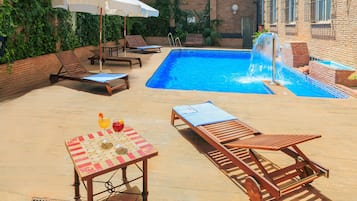 Een seizoensgebonden buitenzwembad en parasols bij het zwembad