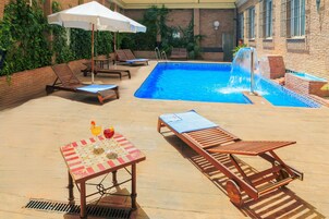 Una piscina al aire libre de temporada, sombrillas