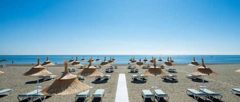 På stranden, solstolar, parasoller och strandhanddukar