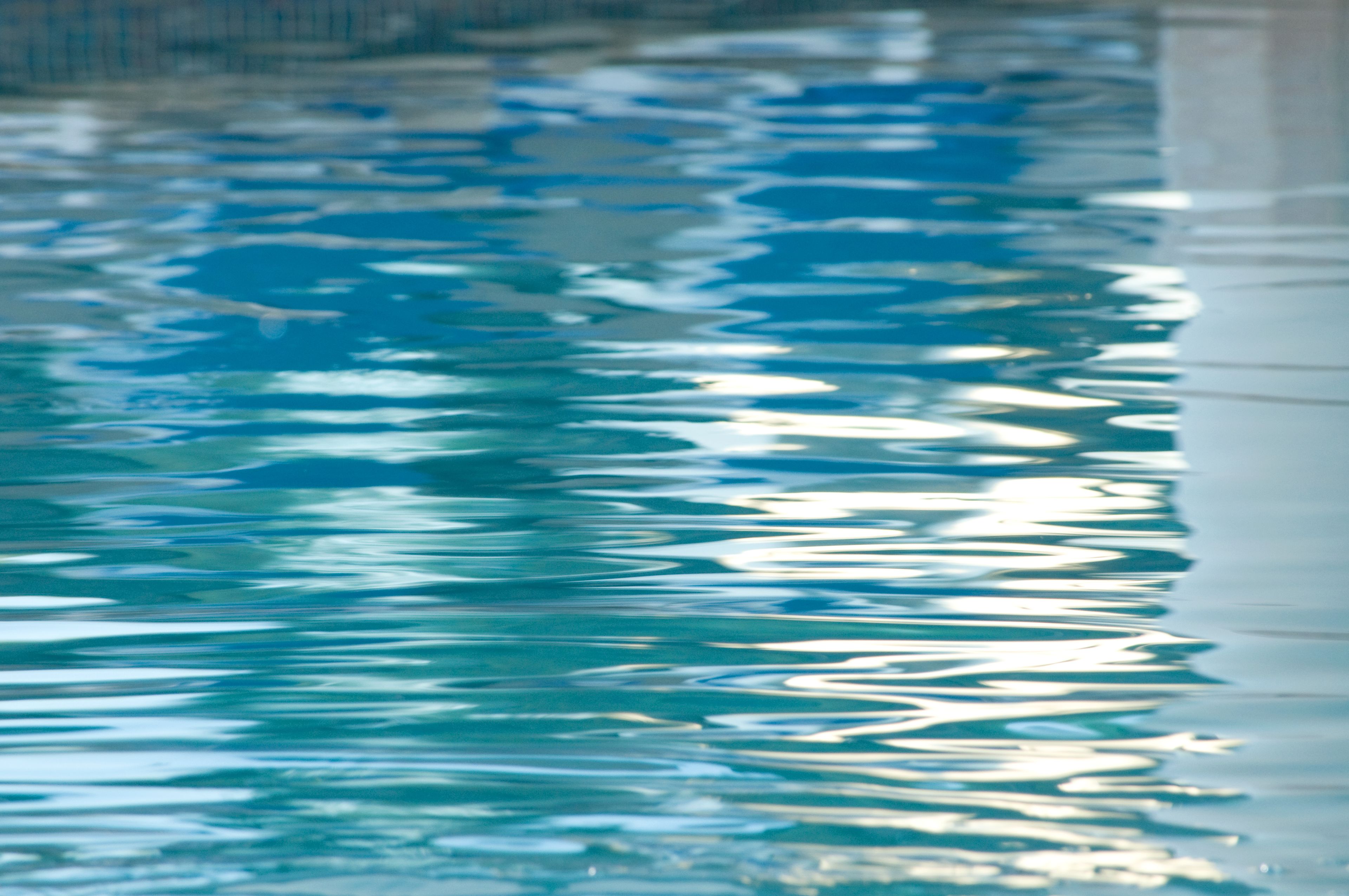Primer plano de una piscina con agua cristalina que refleja la luz.