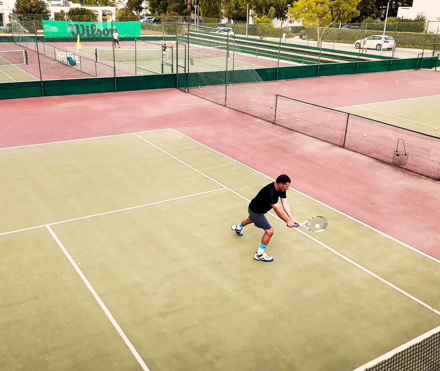 Een tennisbaan met een spelende tennisspeler.