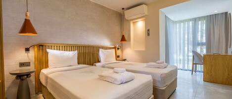 Habitación de hotel con dos camas, un escritorio y una silla.