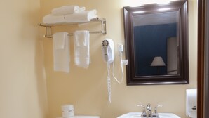 Un baño con inodoro, lavamanos y toallero.