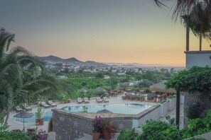 A resort pool area with lounge chairs, umbrellas, and potted plants. - 4Reasons Hotel And Bistro | 12+ (Bodrum)