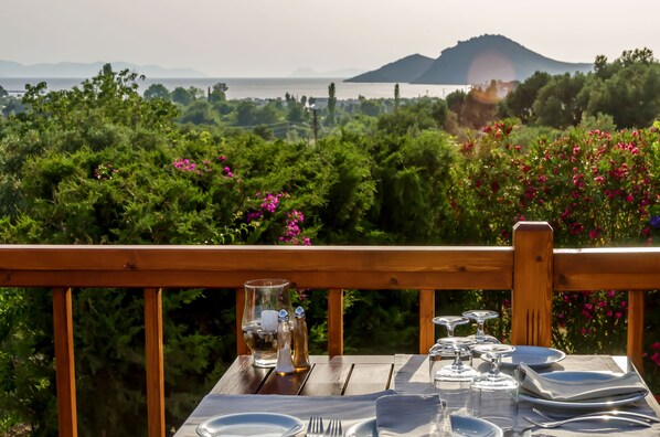Mesa lista para comer con vista a un paisaje montañoso y una masa de agua.