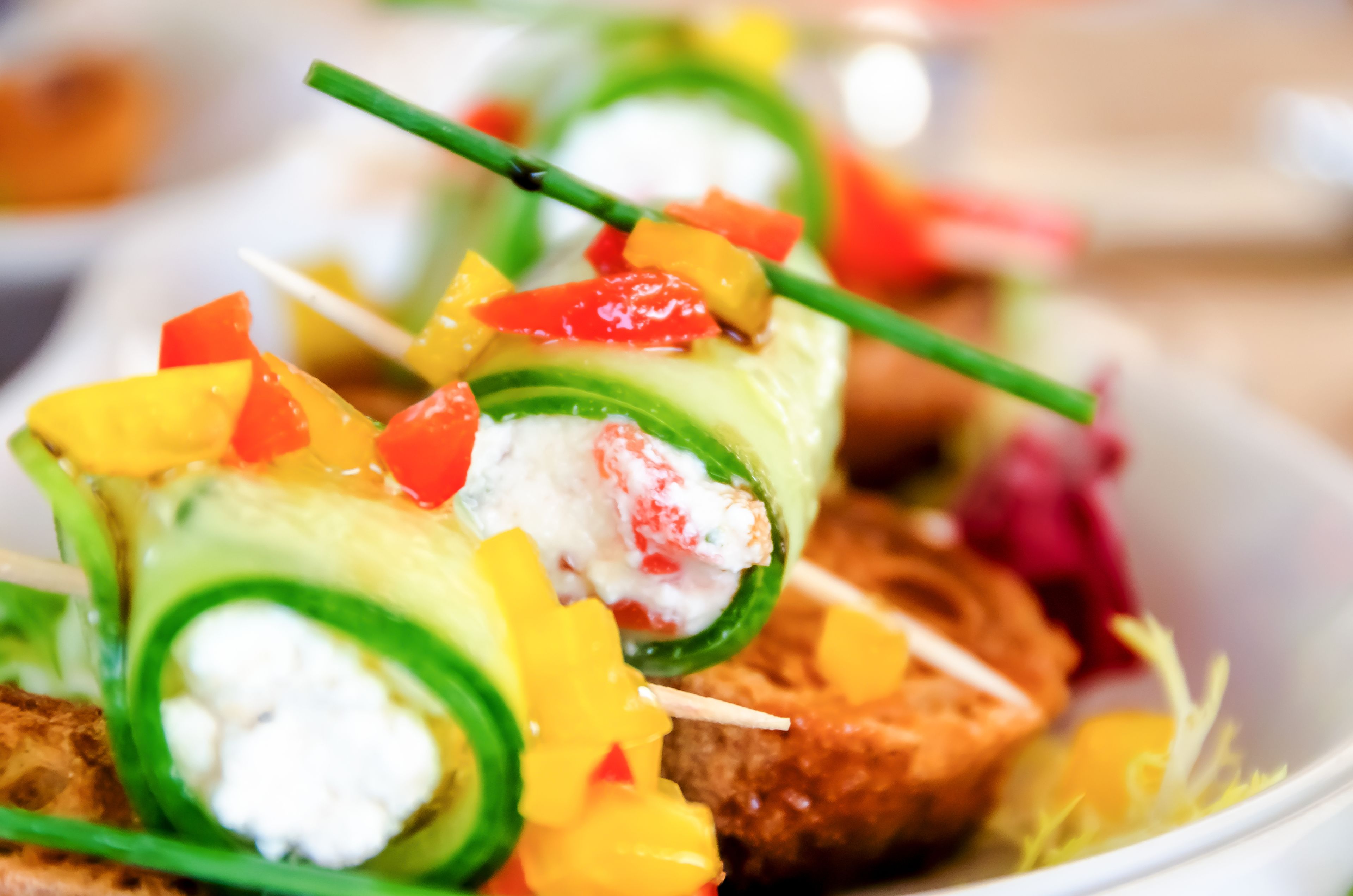 Ein Nahaufnahme eines Gerichts mit Avocado, roten und gelben Paprika sowie einer weißen, cremigen Füllung, vermutlich ein Salat oder Vorspeise.