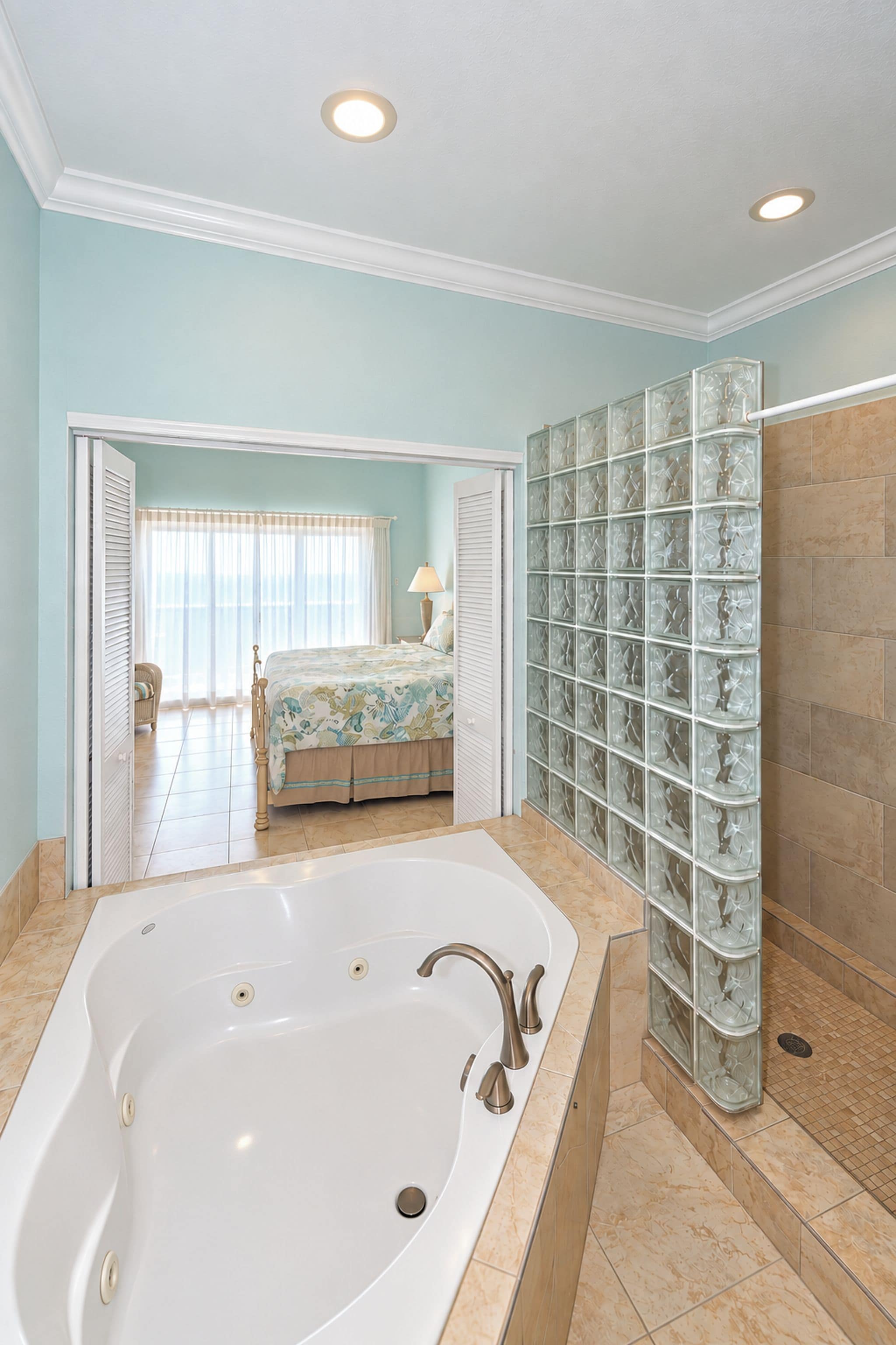 Un baño con una bañera grande, zona de ducha y cabina de vidrio.