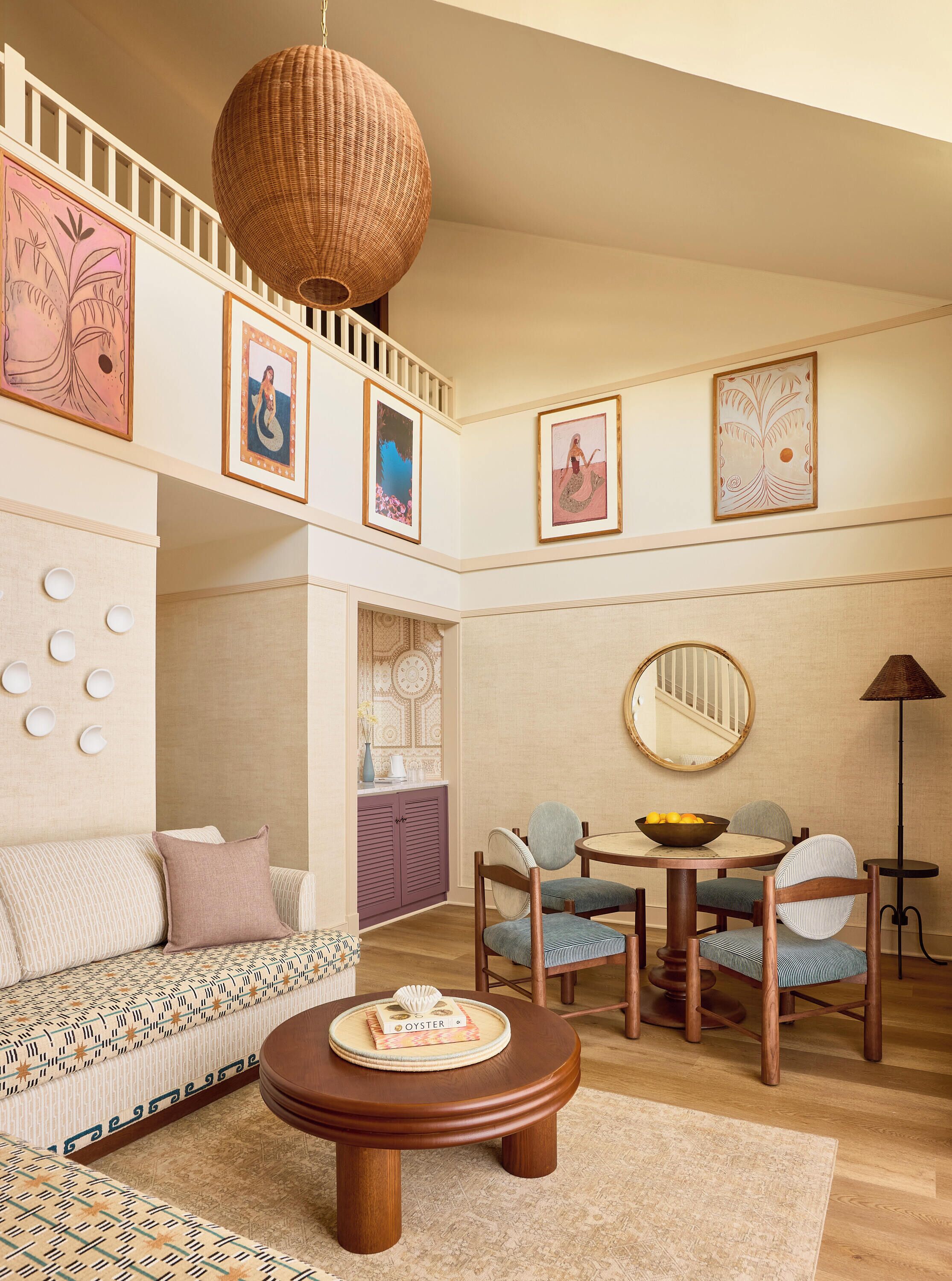A multi-level living space with a dining area, a round wooden coffee table, and a staircase.