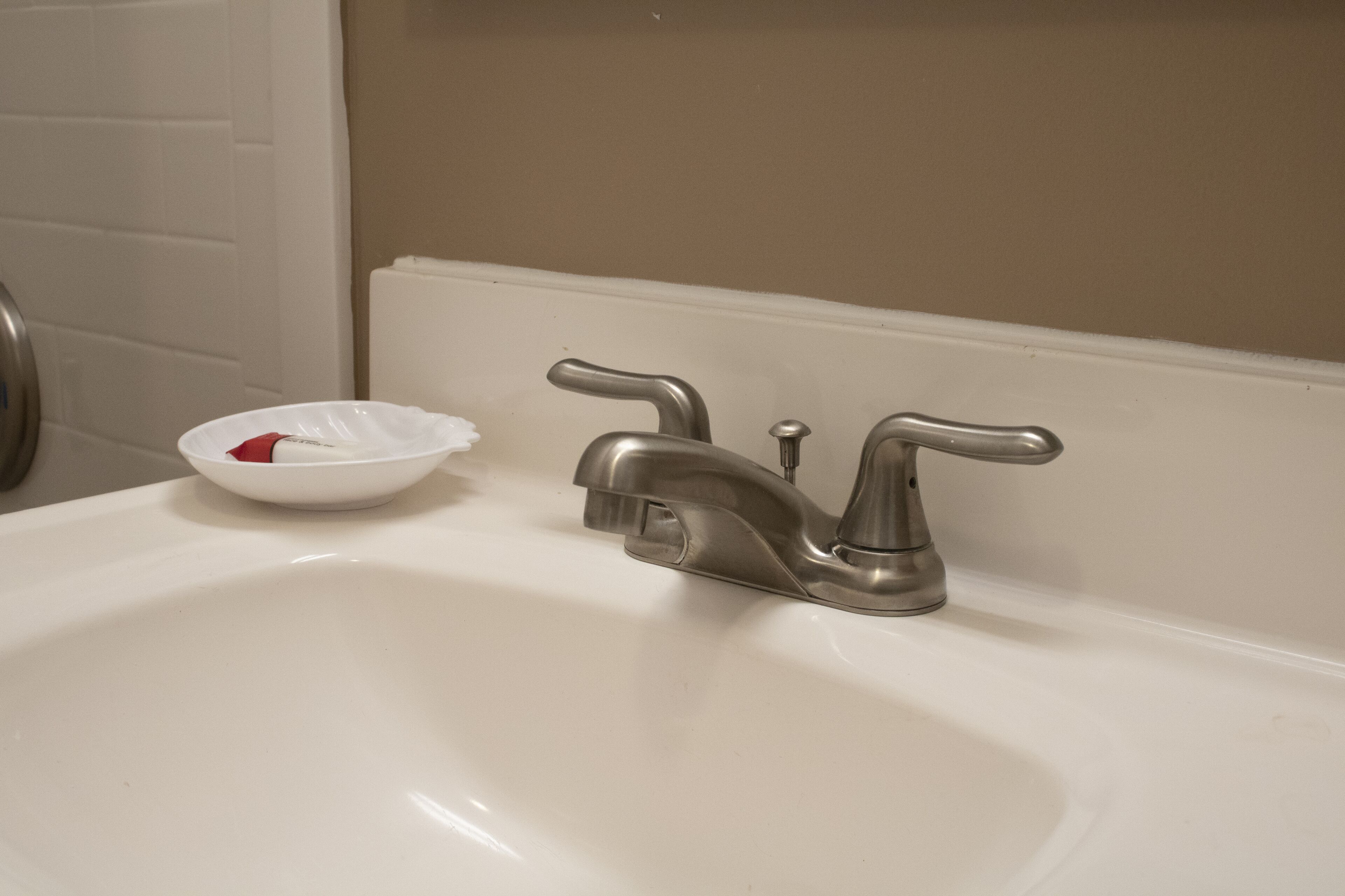 Un lavamanos de baño con un grifo moderno y un lavabo blanco.