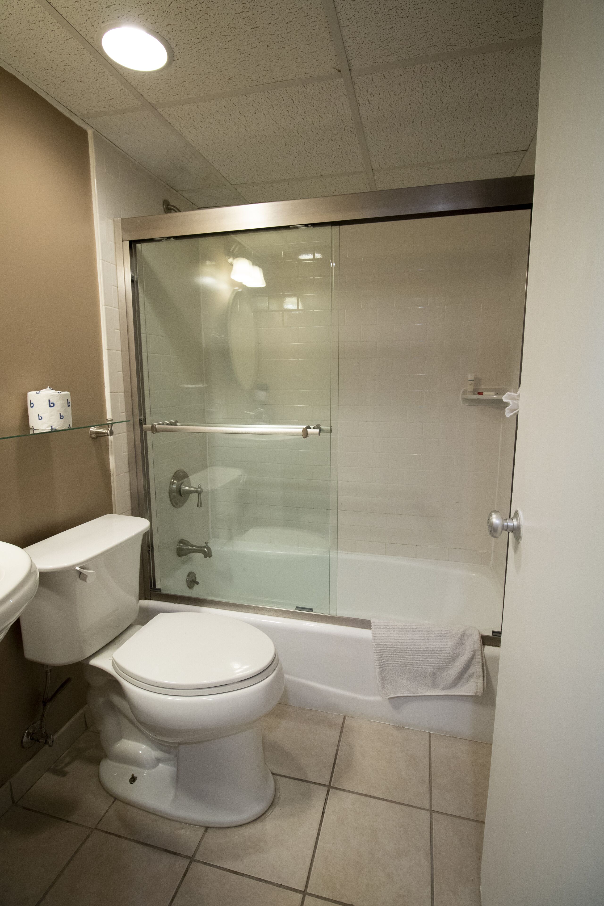 Une salle de bain avec une douche à parois de verre, des toilettes et une baignoire.