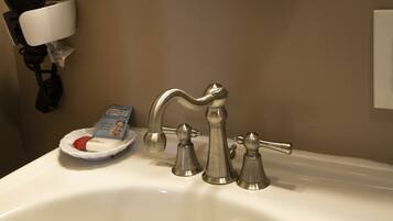 A bathroom sink with a mirror, a faucet, and a soap dish.