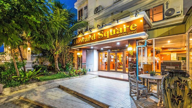 A hotel entrance with a sign reading 'Howard Square,' outdoor seating, and a large decorative vase. - Collection O Howard Square Boutique Hotel (Bangkok)