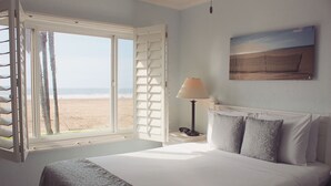 Ein Schlafzimmer mit einem Bett, einem Fenster mit Rollläden, einer Lampe und einem Bild an der Wand.
