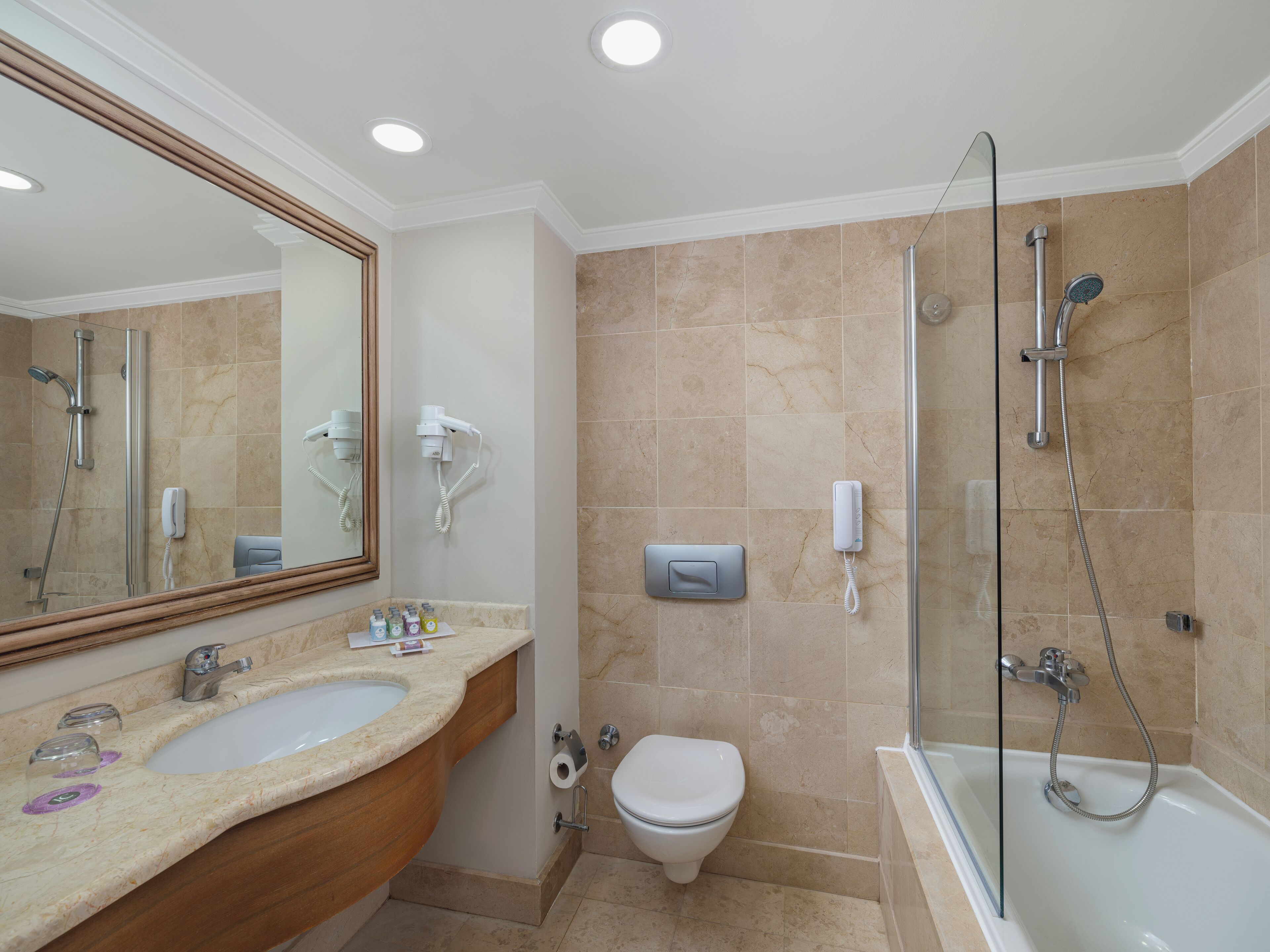 A modern bathroom with a sink, toilet, and shower area.