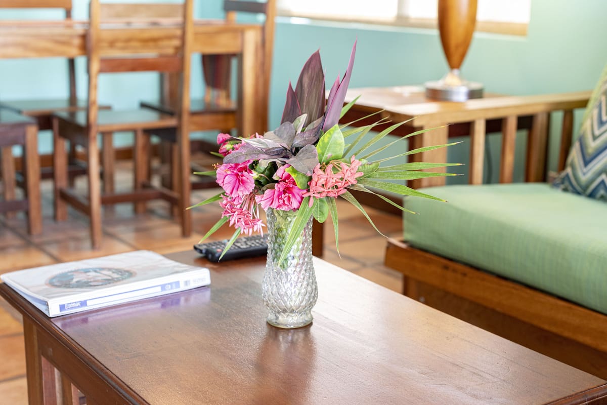 Une table en bois, ornée d’un vase de fleurs et d’un livre.