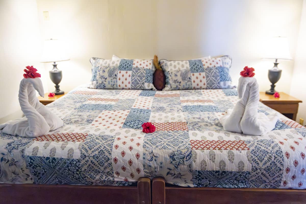 Un lit avec une couette, des oreillers et deux serviettes décoratives.