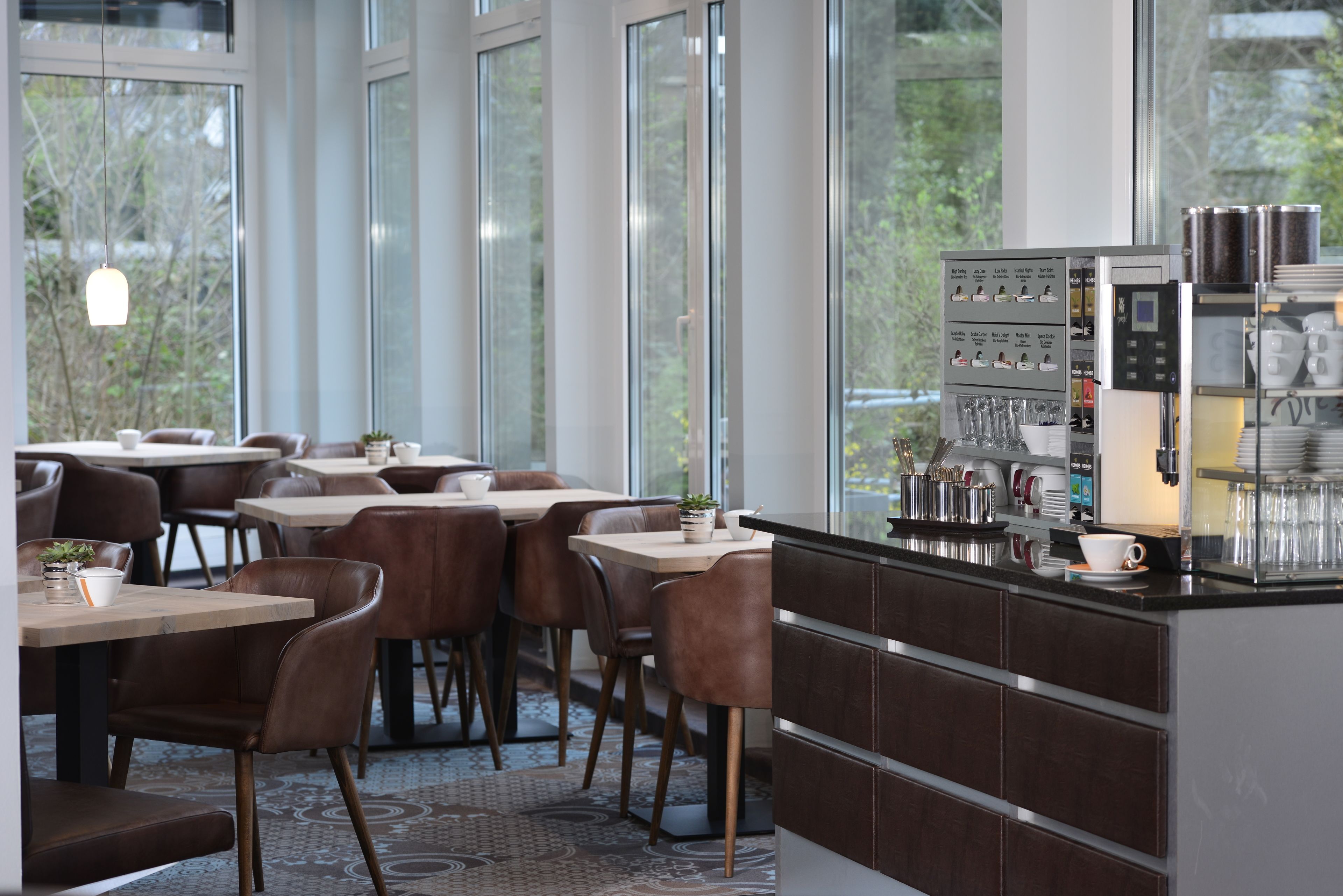 Ein modernes Café mit Barista-Station, Sitzbereich und großen Fenstern.