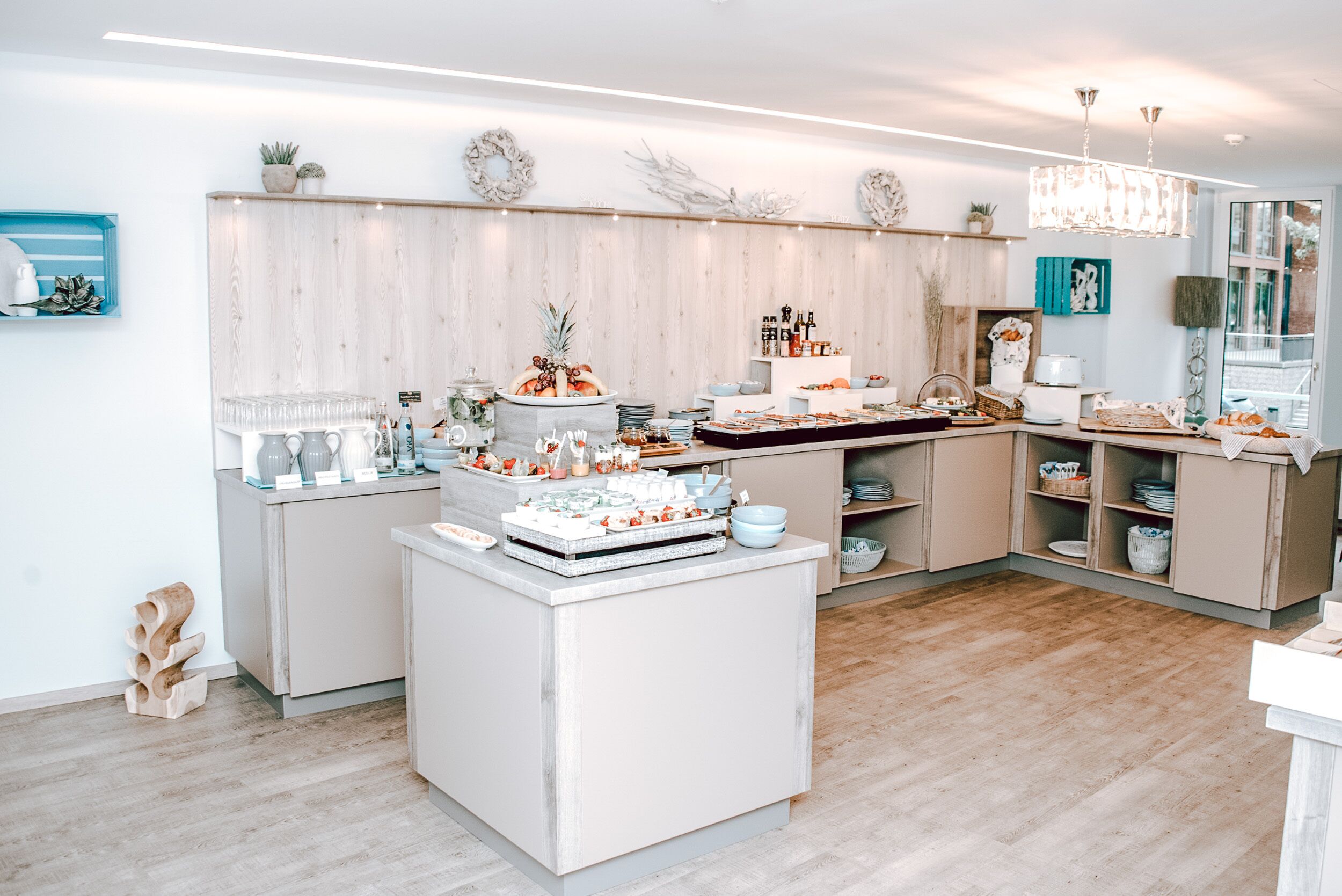 Una cocina moderna con una isla central, armarios de madera y diversos utensilios de cocina.