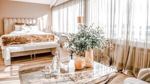 A modern hotel room with a large bed, a wooden coffee table, and a potted plant. - Hotel Concorde (Bad Soden am Taunus)