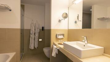 Une salle de bain moderne avec un grand lavabo, un miroir et une douche à parois de verre.